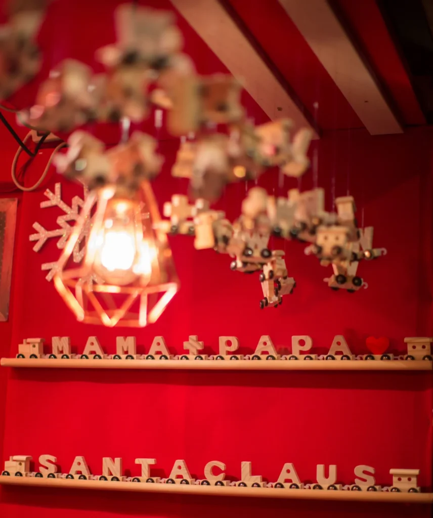 Buchstabenzüge mit Mama + Papa und Santa Claus auf einem Regal am Marktstand