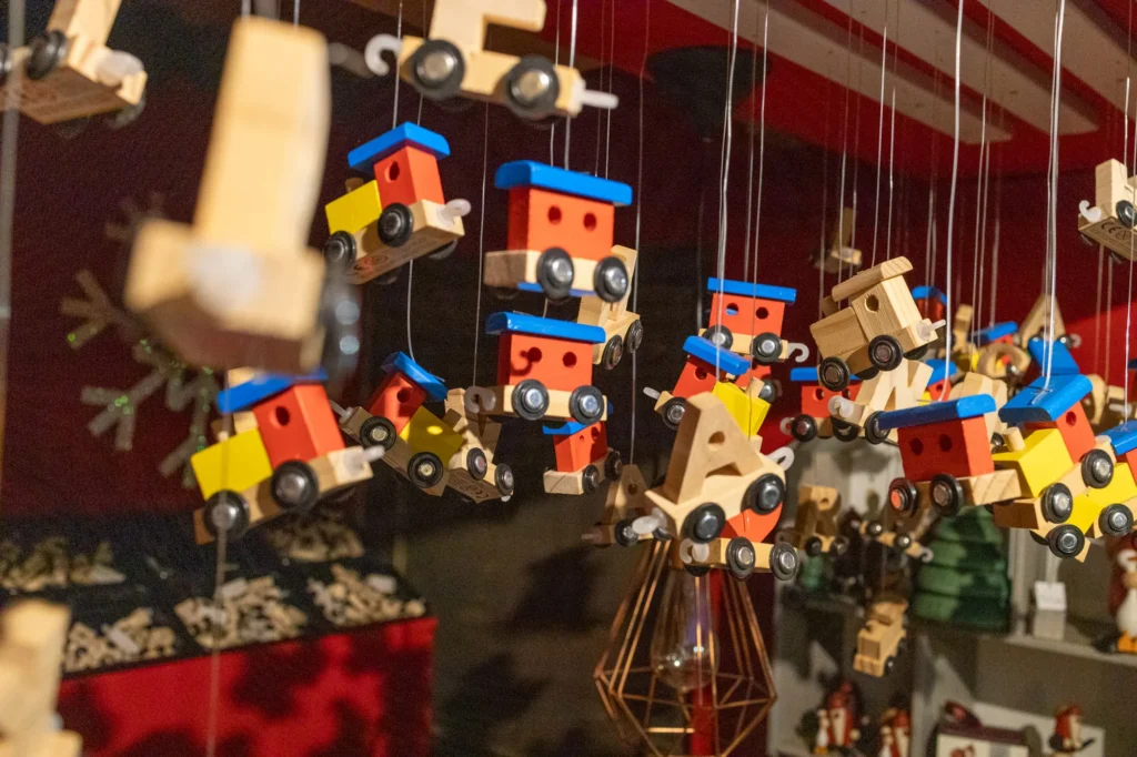 Bunte Holzloks des Buchstabenzugs hängen am Marktstand
