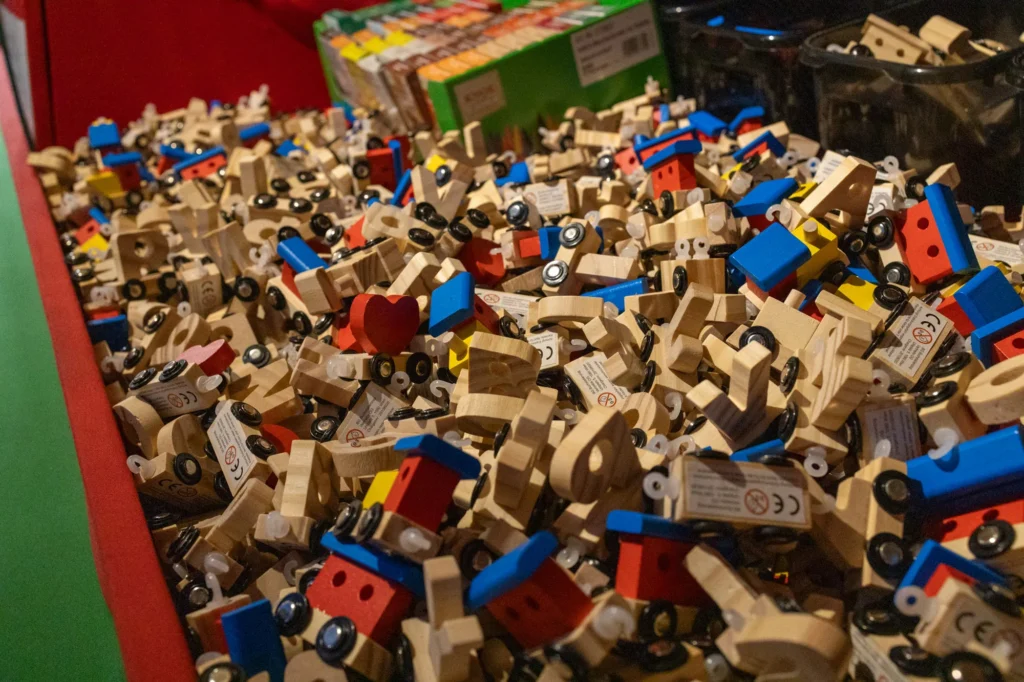 Kiste voller Buchstabenwaggons, Loks und roter Herzen aus Holz