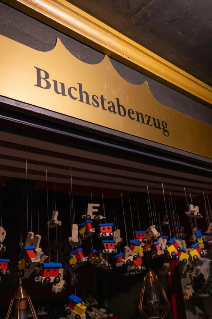 Schild Buchstabenzug über dem Marktstand mit hängenden Zügen